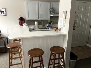 a kitchen with a counter and two stools at Deluxe Ski On Off 1BR Suite Sleeps 4 on Jiminy Mtn in Hancock