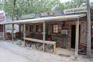 a wooden cabin with a sign on top of it at Acorn Hideaways Canton Cozy Frontier Suite 1890s Cattle & Land Decor in Canton