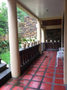 een veranda met potplanten en een stenen muur bij Baguio Rest House in Baguio