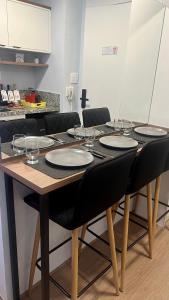 a table with black chairs and wine glasses on it at MV 148A Espetacular Apartamento Em Frente Ao Metrô Brás ! - Rua Coronel Mursa, 56 - Bras in Sao Paulo