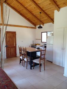 cocina con mesa de comedor y sillas en Cabaña La Quinta N 1, en Talca