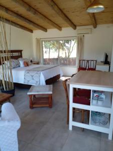 1 dormitorio con 1 cama, mesa y sillas en Cabaña La Quinta N 1, en Talca
