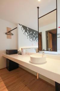 a bathroom with a sink and a large mirror at KOO HOTEL in Ban Bang Talat