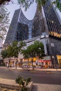 a tall building with a street in front of it at Capitalia Plaza Residences Reforma in Mexico City