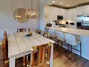 a kitchen with a large wooden table and chairs at Adagio 303E in Santa Rosa Beach