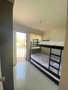 um quarto com 2 beliches e uma varanda em Hermoso apartamento con vista a la Sierra em Santa Marta