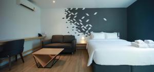 um quarto de hotel com uma cama e uma cadeira em KOO HOTEL em Ban Bang Talat