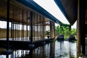 a building with a pool of water in front of it at Let's Get Lost Ubud in Ubud