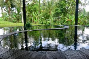 a pool of water on the floor of a house at Let's Get Lost Ubud in Ubud