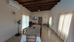 un salon avec une table, des chaises et des fenêtres dans l'établissement Casa Con Pileta Privada, à General Alvear