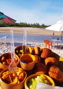 ein Tablett mit Essen auf einem Tisch am Strand in der Unterkunft Casa Amarela na Praia de Guaibim-Taquari in Guaibim