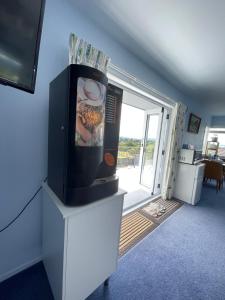 a room with a tv on a table with a window at Panoramic View Apartment Without a Kitchen in Rotorua