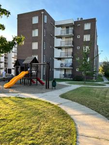 um parque infantil em frente a um edifício com escorrega em Departamento 2D 1B Lircay em Talca