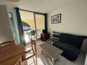 salon z kanapą i stołem w obiekcie Appartement avec Piscine, Parking Privé, Lave-Vaisselle – À 150m de la Plage - FR-1-702-36 w Cap d'Agde