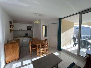 d'une cuisine et d'une salle à manger avec une table et une fenêtre. dans l'établissement Appartement Cap d'Agde, 2 pièces, 6 personnes - FR-1-702-36, au Cap d'Agde