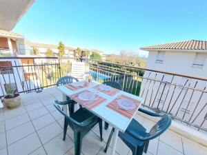 stół i krzesła na balkonie w obiekcie Appartement 2 pièces avec accès direct plage, piscine et terrasse - Marseillan - FR-1-326-778 w mieście Marseillan