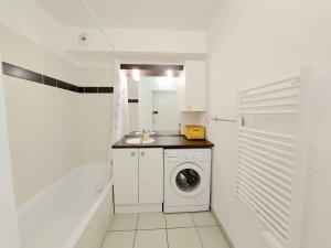 biała łazienka z pralką i umywalką w obiekcie Appartement 2 pièces avec accès direct plage, piscine et terrasse - Marseillan - FR-1-326-778 w mieście Marseillan
