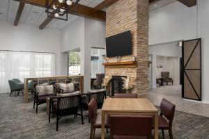 una hall con camino, tavoli e sedie di Staybridge Suites San Antonio Airport, an IHG Hotel a San Antonio