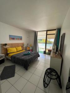 ein Schlafzimmer mit einem Bett mit gelben Kissen darauf in der Unterkunft OCEANE 2 in Le Gosier