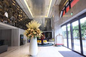 un vestíbulo con un gran jarrón con flores en 冠月精品旅館-Puli Ease Hotel en Puli