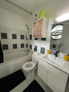 ein Badezimmer mit einem weißen WC und einem Waschbecken in der Unterkunft OCEANE 2 in Le Gosier