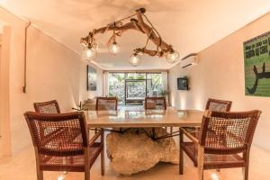 a dining room with a large wooden table and chairs at Tulum Retreat-3BR Luxury Condo-Private Pool in Tulum