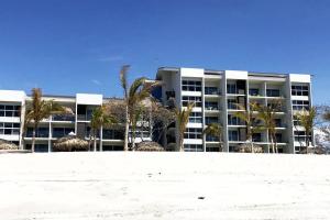 a large building with palm trees in front of it at Playa Caracol, beach happy in Chame