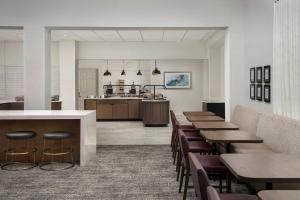 a restaurant with tables and chairs and a kitchen at Staybridge Suites San Antonio Airport, an IHG Hotel in San Antonio