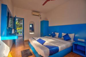 a blue bedroom with a bed with a blue wall at Mandrem Retreat Beach resort in Mandrem