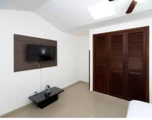 Habitación con puerta y TV en la pared en NAMASTE ELEAN 2A, en Cali