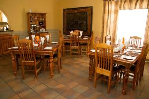 una sala da pranzo con tavoli e sedie in legno di 26 On Chamberlain Guest House a Queenstown