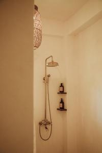 y baño con ducha y luz en la pared. en Vedya Boutique Hostel, en General Luna