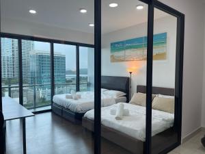 two beds in a room with a view of the ocean at Almas Suites Double Bed @Legoland in Nusajaya