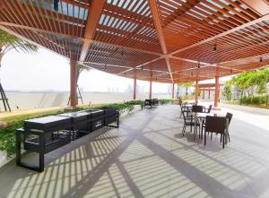 a patio with tables and chairs under a roof at Almas Suites Double Bed @Legoland in Nusajaya