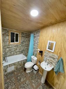 a bathroom with a tub and a toilet and a sink at Refugio El Chucao in Hornopiren
