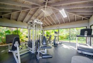 a gym with treadmills and exercise equipment and windows at Tropical Paradise Key West in Key West