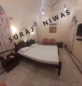 un dormitorio con una cama con las palabras mumas en la pared en Suraj Niwas, en Jaipur