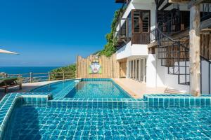 a swimming pool with a view of the ocean at Villa at Nai Harn Cape / Ocean Point in Nai Harn Beach