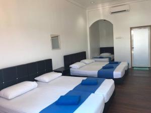 Cette chambre comprend 4 lits avec des oreillers bleus. dans l'établissement Perhentian Nemo Chalet, aux Îles Perhentian