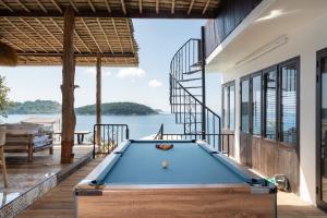 a pool table on a deck with a view of the water at Villa at Nai Harn Cape / Ocean Point in Nai Harn Beach