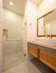 Navela Hotel & Convention في راتشابوري: حمام مع حوض ومرآة