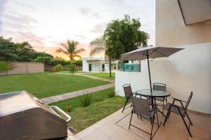 a patio with a table and chairs and an umbrella at Casa Amor in Puerto Vallarta