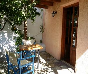 a table and chairs in front of a house at Exclusive Cottage in S West Crete in a quiet olive grove near the sea in Palaiochóra