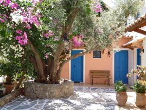 uma árvore em frente a um edifício com flores cor-de-rosa em Amazing Cottage close from the sea - Crete em Palaiochora