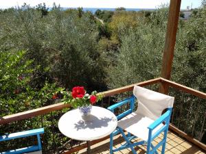 uma mesa com duas cadeiras e um vaso de flores numa varanda em Amazing Cottage close from the sea - Crete em Palaiochora