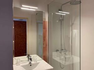 uma casa de banho com um lavatório, um chuveiro e um espelho. em Appartement Perros-Guirec, 3 pièces, 4 personnes - FR-1-368-59 em Perros-Guirec