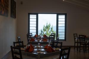 a dining room with a table with red pillows at Dvara Luxury Resort Kodaikanal in Kodaikānāl