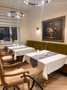un restaurant avec des tables et des chaises et une peinture murale. dans l'établissement Hotel Dastan Aktobe, à Aqtöbe