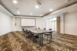 una sala de conferencias con una mesa grande y sillas en Holiday Inn Melbourne Airport, an IHG Hotel en Melbourne