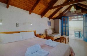 a bedroom with a large bed and a chair at Exclusive Cottages are in S West Crete in a quiet olive grove near the sea in Palaiochora